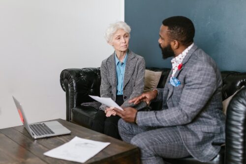older woman discussing plans with young man in suit