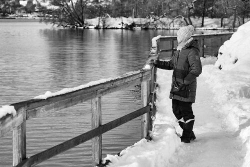 woman standing alone on snowy bridge